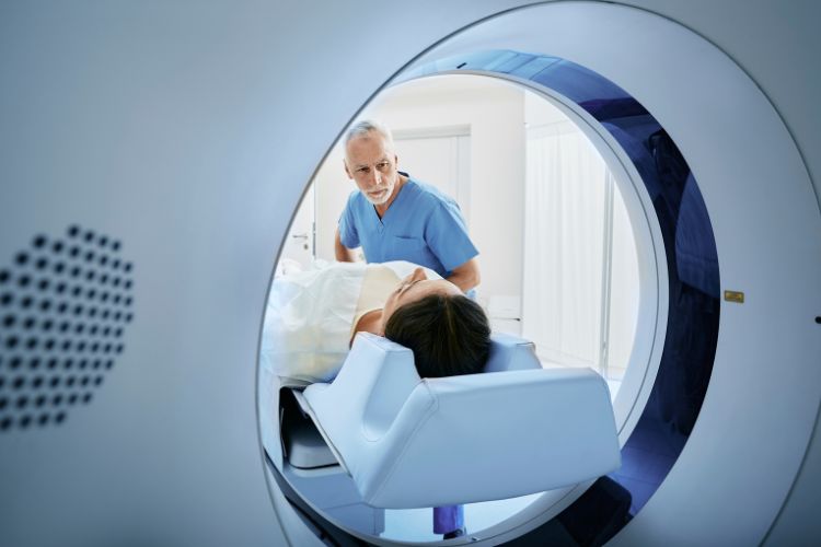 technician looking into ct scanner